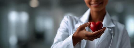 A woman in a white coat holding a red heart photo