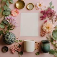 Flowers and vases with paper and cup on pink background photo