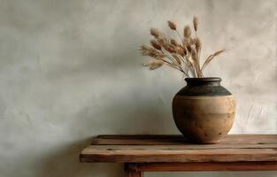 A brown vase with dried grass in it photo