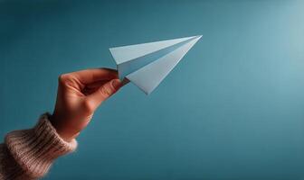 A person holding a paper airplane in their hand photo