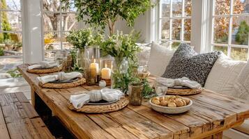 A rustic dining room table with white pillows and a vase of flowers photo