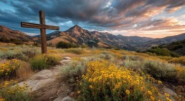 Sunset over the mountains and cross in the foreground photo
