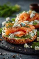 Smoked salmon bagel with cream cheese and dill pickles on a slate photo
