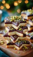 A stack of chocolate star cookies with pistachios on top photo