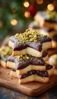 A stack of chocolate cookies with pistachios on top photo