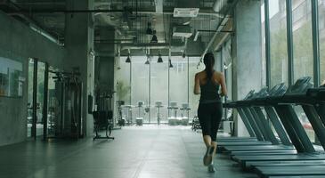 A woman running on a treadmill in a gym photo