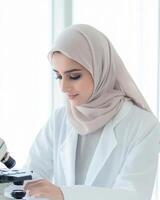 Focused Muslim Scientist Using Microscope in Lab photo
