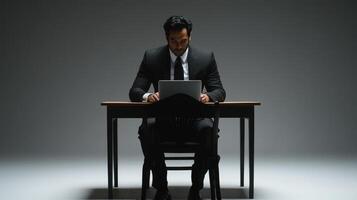 Focused Businessman Working on Laptop in Minimalist Studio Setting photo