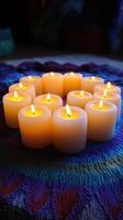 Burning candles arranged in a circle on a colorful textile photo