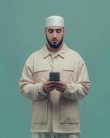 A Muslim Man Using Smartphone, Wearing Traditional Cap and Beige Jacket, Calm and Focused Expression photo