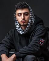 Portrait of a Young Man in a Black Hoodie with a Keffiyeh, American Flag Patch photo