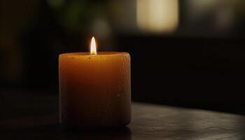 A single lit candle sits on a dark surface photo