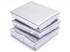 Stacked Silver Metallic Gift Boxes On White Background Reflecting Light With Geometric Shapes photo