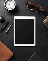 Workspace Overhead View Featuring Digital Tablet and Office Accessories on Dark Background photo