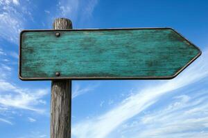 Weathered Turquoise Signpost Pointing Right Against A Bright Blue Sky photo