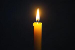 A Single Lit Candle Against A Dark Background photo