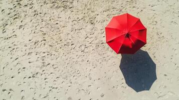 Couple Walking on Sandy Beach with Red Umbrella Overhead photo