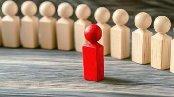Red figure stands out among wooden figures in line photo