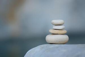 Natural stone stack on smooth surface by water photo