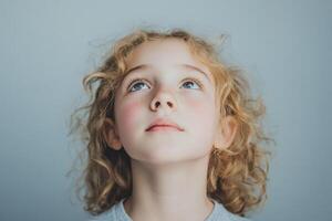 Child gazing upwards with curiosity in soft light photo