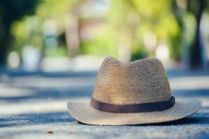 Stylish straw hat resting on the ground in a park photo