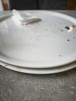 Empty plates with remnants of food and a napkin on a table showcasing the aftermath of a meal dining experience and food enjoyment concept photo