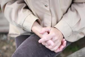 Woman's hands clasped in a gesture of contemplation. photo