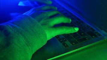 hacker digitando em uma computador portátil dentro baixo luz com verde brilho, cyber crime conceito video