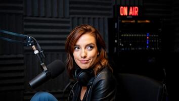 Podcast host engages with listeners during a live recording session in a professional studio with an on air sign illuminated in the background photo