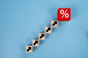 Red wooden blocks arranged as a bar graph with upward arrows and percentage symbols. photo