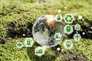Sustainable transport and energy icons around transparent globe on green moss, ESG and net zero concept art photo