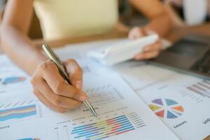 Close-up of a person reviewing financial data with charts, graphs, and a calculator, highlighting business analysis and planning. photo