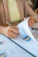 Close-up of a person reviewing financial charts and graphs, data analysis and business strategy. photo