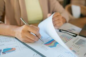 Close-up of hands reviewing financial documents with charts and graphs, highlighting business analysis and strategic planning. photo