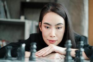 A woman deeply contemplating her next move in a game of chess, set in a contemporary indoor environment. photo