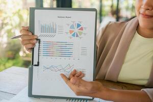 Close-up of a business professional presenting a financial summary report with colorful graphs and charts. photo