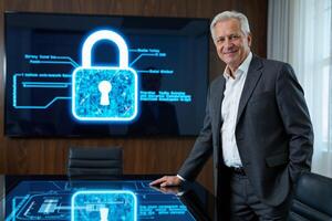 A man in a suit standing in front of a screen with a padlock on it photo