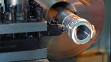 Close-up of turning process on metal lathe machine, Cutting tool shaping spinning cylindrical part in precision machining video