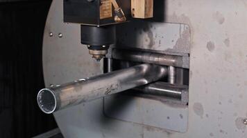 Laser cutter processing metal pipe on industrial CNC machine, Close-up view of tube cutting in automated fabrication setup video