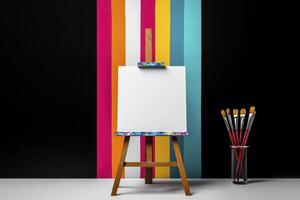 Blank Canvas on Easel with Paintbrushes and Colorful Striped Background photo