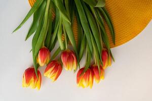 Bouquet of orange-red tulips on the table with space for text. Top view photo
