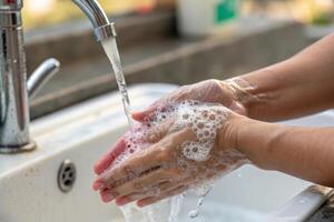 Washing hands with soap under running water, promoting hygiene and cleanliness. image captures importance of handwashing in daily routines photo
