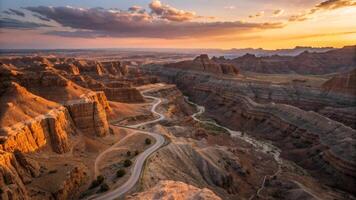 A breathtaking aerial view of winding road through canyon landscape at sunset, showcasing dramatic rock formations and vibrant colors of sky photo