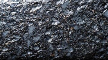 This textured black granite features a variety of unique patterns and intricate details, making it suitable for backgrounds and mockup designs in various settings. photo