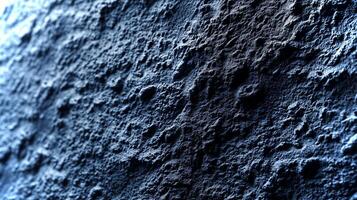 This close-up view showcases the unique textures and patterns on a dark rock surface illuminated by soft light, reflecting natural geological features. photo