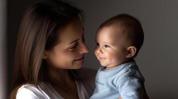 In a serene setting, a mother gazes adoringly at her adorable baby, creating a warm and intimate atmosphere filled with love and joy. photo
