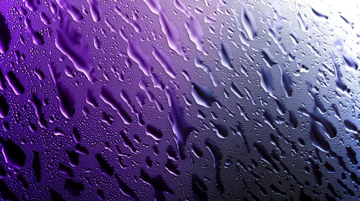 Raindrops cling to a glass surface, forming intricate patterns against a moody purple backdrop, creating an ideal texture for design purposes.