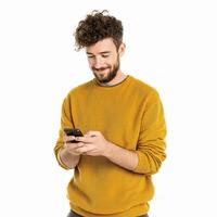 A man in a yellow sweater is looking at his phone photo