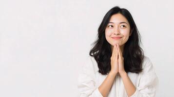 Asian woman praying with hands crossed over white background photo