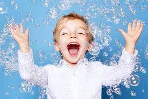 A young boy is laughing while playing with bubbles photo